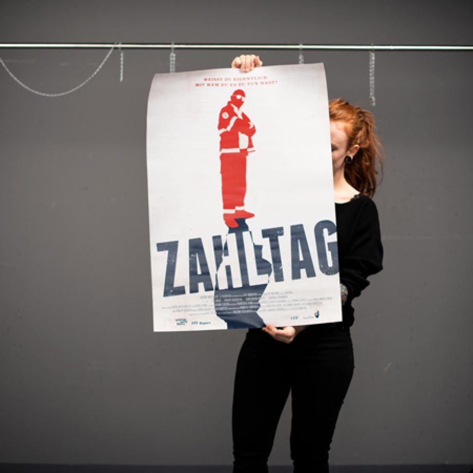 Photography of Nina Lesznik holding a lange film poster of "Zahltag"